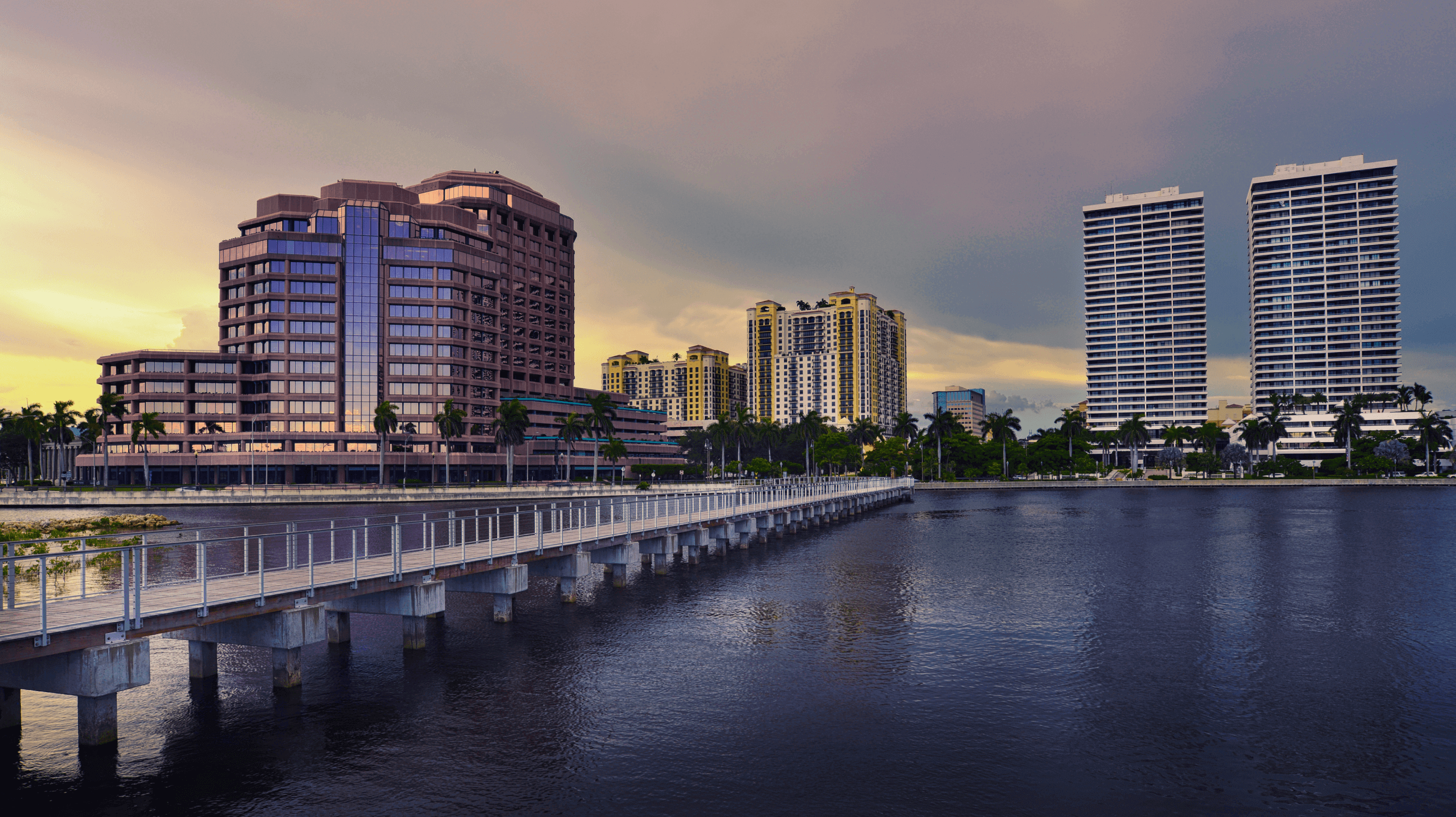 Downtown West Palm Beach buildings with a pier in the foreground.