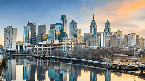 A river and various sized buildings in downtown Philadelphia, PA.